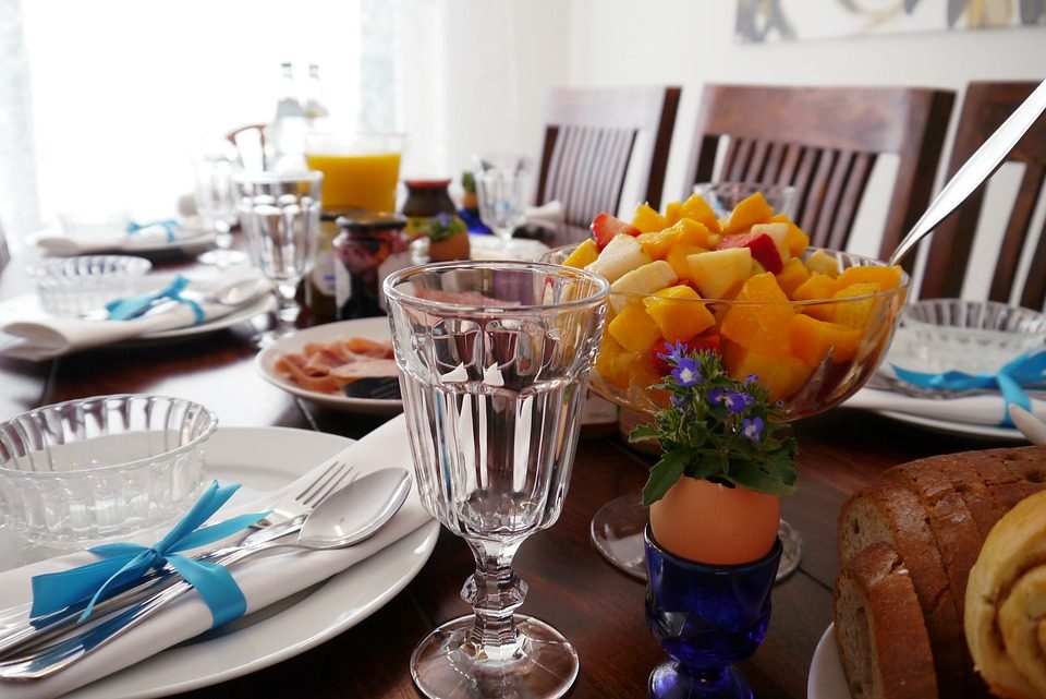 Gedekte brunchtafel met fruitsalade, brood en glazen