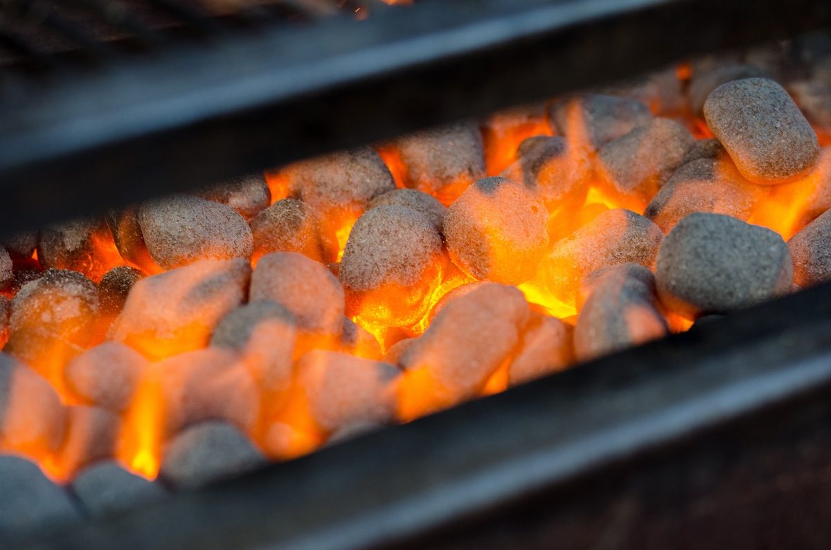 Gloeiende barbecuebriketten in een grill