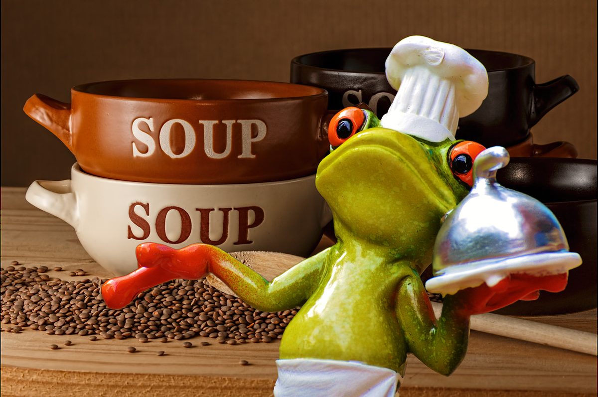 Kikkerfiguurtje verkleed als kok met soepkommen