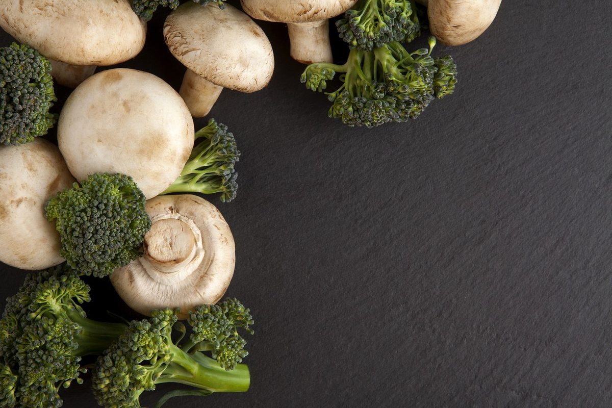 Champignons en broccoli op een donkere leisteen