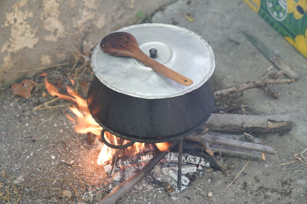 Pan met deksel op een houtvuurtje buiten