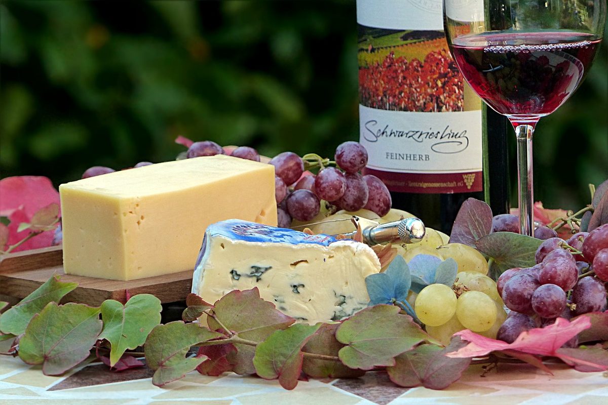 Stilleven met kaas, druiven en een glas rode wijn